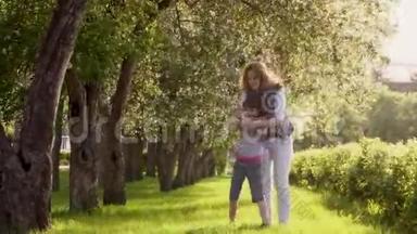 母亲在一个苹果园里拥抱女儿。 母亲和女儿沿着苹果树的林荫道散步。 <strong>儿童</strong>和<strong>儿童</strong>